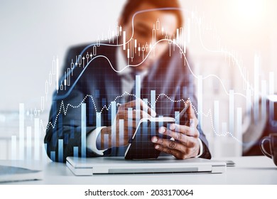 African American businessman is holding notebook and taking notes. Office workplace with laptop in the background. Forex candlestick and financial graph in the foreground. Concept of trading - Powered by Shutterstock