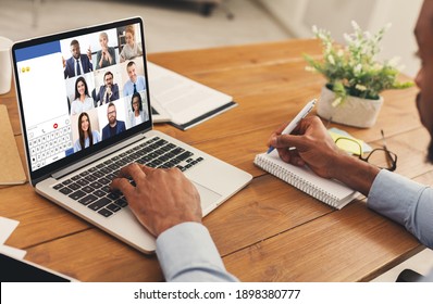 African American Businessman At Laptop Making Video Call Having Online Business Meeting With Group Of Coworkers Sitting At Workplace In Office. Modern Distance Communication. Selective Focus, Cropped