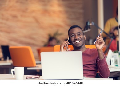 African American Businessman On The Phone Sitting At The Computer In His Startup Office