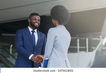 African american businessman shaking hands with his female partner celebrating successful teamwork. Copy space