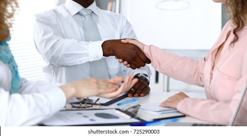 African american businessman shaking hands with female partner in office - Shutterstock ID 725290003