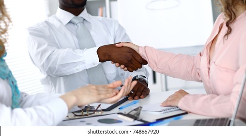 African american businessman shaking hands with female partner in office - Shutterstock ID 748667920