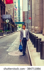 African American Businessman Traveling, Working In New York. Young Black Man Walking On Narrow Old Street With High Buildings, Carrying Blue Bag. Car Running On Background. Instagram Filtered Effect.
