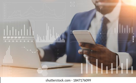 African American Businessman Using Cellphone And Laptop At Workplace, Collage With Company Analytics On Imaginary Screen. Online Business Management Or Marketing Strategies Concept