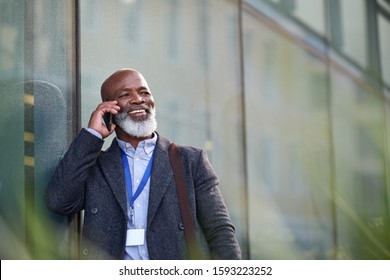 African american businessman using smartphone talking on mobile phone call having conversation in city