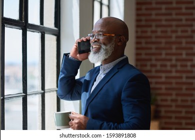 African american businessman using smartphone talking having phone call conversation in office looking out window - Powered by Shutterstock