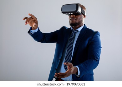 African american businessman wearing vr headset gesturing against grey background. business, professionalism and technology concept - Powered by Shutterstock