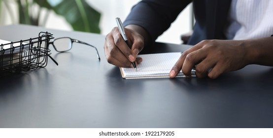 African american businessman writing down his ideas in notebook - Shutterstock ID 1922179205