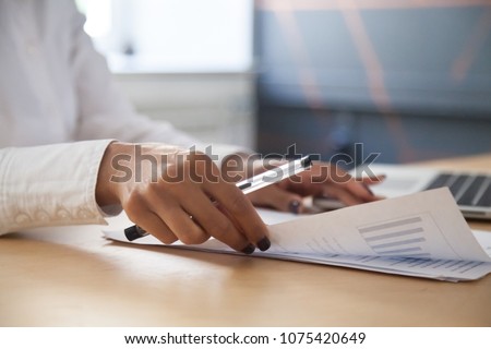 African american businesswoman analyzing project statistics result in report working with graphs documents and laptop in office, strategic planning and financial data analysis concept, close up view