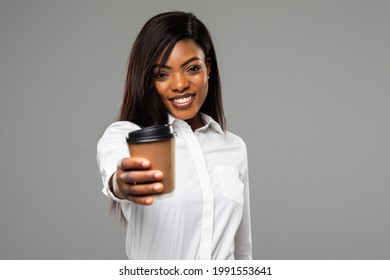 african american businesswoman with business newspaper and coffee to go isolated on grey background