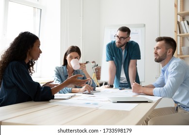African american businesswoman coaching in boardroom at company meeting. Confident black woman training corporate team at briefing. Young diverse employee share thoughts sit at table. - Shutterstock ID 1733598179