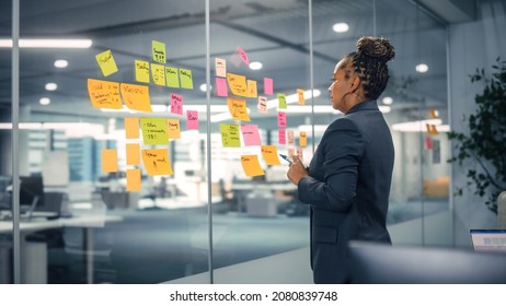 African American Businesswoman Creating Project Plan on Office Wall with Paper Notes. Stylish Confident Manager Working on Business, Financial and Marketing Projects. Specialist in Diverse Team. - Shutterstock ID 2080839748