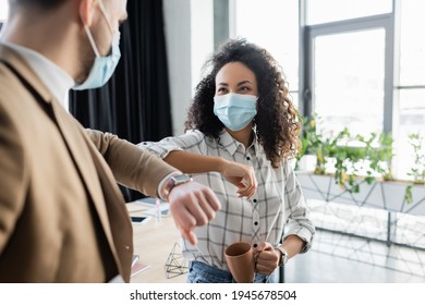 african american businesswoman doing elbow bump with colleague on blurred foreground - Powered by Shutterstock