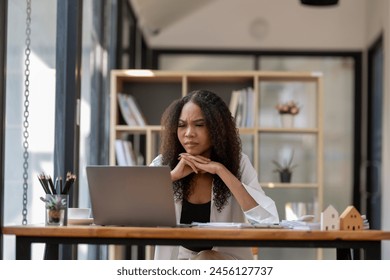 African American businesswoman expressing frustration and confusion while working on her laptop in a modern office setting.

 - Powered by Shutterstock