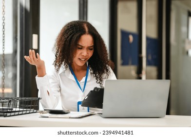 African American businesswoman at her desk, looking stressed and troubled, possibly over a challenging issue at work. - Shutterstock ID 2394941481