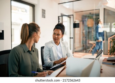 African American businesswoman and her female colleague going through paperwork while working in the office. - Shutterstock ID 2172362643