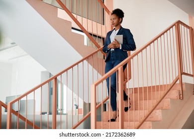 African American businesswoman holding digital tablet while walking down the stairs at work. Copy space. - Shutterstock ID 2172362689
