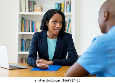 African american businesswoman talking to lazy employee at office