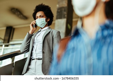African American businesswoman wearing face mask against viruses while walking through railroad station corridor.  - Shutterstock ID 1678406335