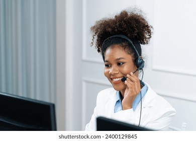 African American businesswoman wearing headset working in office to support remote crucial customer or colleague. Call center, telemarketing, customer support agent provide service on video call. - Powered by Shutterstock