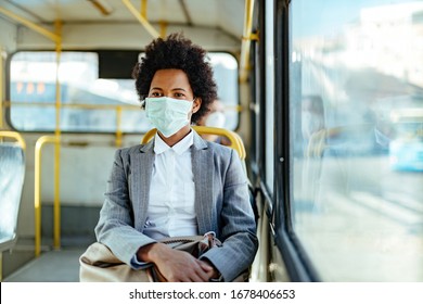 African American businesswoman wearing protective mask while traveling by public transportation.  - Powered by Shutterstock