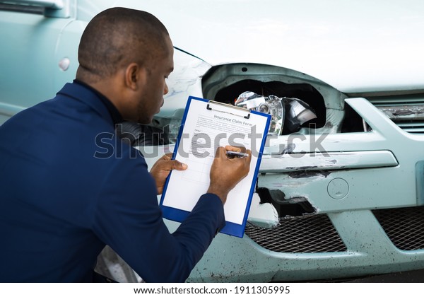 African American Car Insurance Agent Inspecting\
Accident Claim