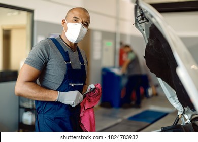 African American car mechanic with face mask working in auto repair shop during coronavirus pandemic.  - Powered by Shutterstock