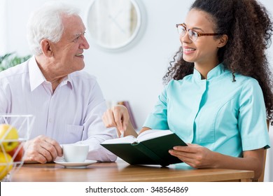 African American Caregiver Keeping Senior Man Company