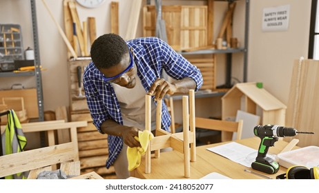 African american carpenter finely sands a handmade chair in a well-equipped woodworking workshop - Powered by Shutterstock