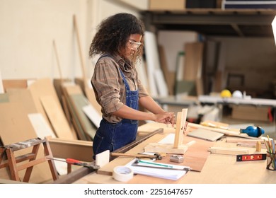 African american carpenter happy working in making woodcraft furniture in wood workshop look professional high skill real people workman.