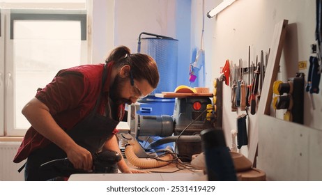 African american carpenter in joinery watching apprentice using orbital sander on lumber. Team in woodworking shop using angle grinder to create wooden decorations, refining wood objects, camera B - Powered by Shutterstock