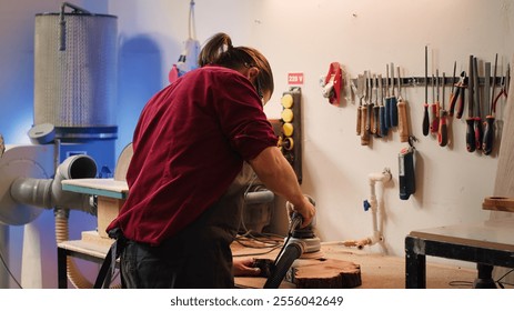 African american carpenter in joinery watching apprentice using orbital sander on lumber. Team in woodworking shop using angle grinder to create wooden decorations, refining wood objects, camera A - Powered by Shutterstock