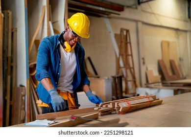 African American carpenter man look happy to work with timber in factory workplace in concept of happiness environment for worker increase quality of work. - Powered by Shutterstock