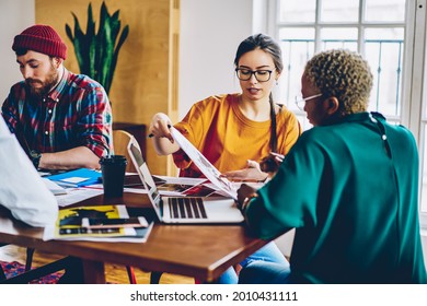 African American and Caucaisan female colleagues analyzing paper report discussing business details during work time for collaborate, diverse students communicate during together studying indoors - Shutterstock ID 2010431111