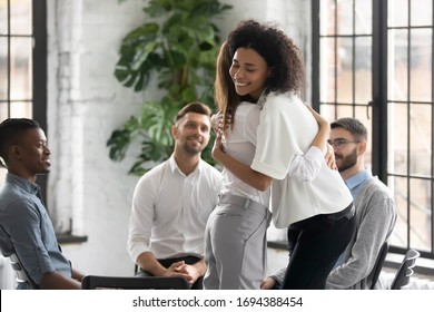 African American And Caucasian Women Embracing At Group Therapy Session. Psychological Support Concept Of Diverse Friends Overcome Problem Together, Addiction Treatment Or Team Building.