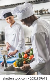 African American Chef Washing Vegetables At Restaurant Kitchen