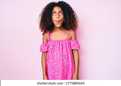 African American Child With Curly Hair Wearing Casual Dress Making Fish Face With Lips, Crazy And Comical Gesture. Funny Expression. 