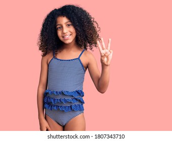 African American Child With Curly Hair Wearing Swimwear Showing And Pointing Up With Fingers Number Three While Smiling Confident And Happy. 