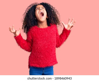 African American Child With Curly Hair Wearing Casual Winter Sweater Crazy And Mad Shouting And Yelling With Aggressive Expression And Arms Raised. Frustration Concept. 