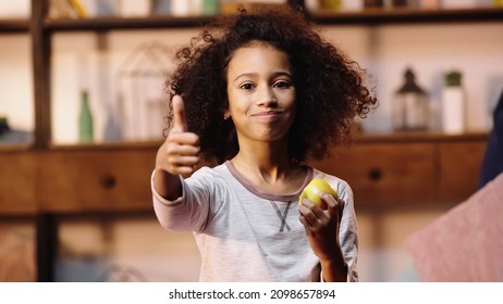 African American Child Showing Thumb Up While Eating Apple