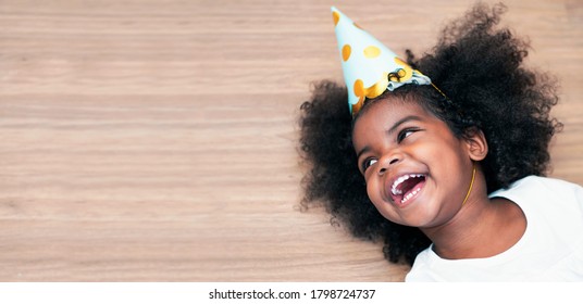 African American child wears New Year's hat and laughs happily.           - Powered by Shutterstock