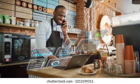 African American Coffee Shop Owner Is Working On Computer And Talking On A Phone In A Cozy Cafe. Augmented Reality Icons Popping Out Of Restaurant Manager's Laptop: Small Business Concept.