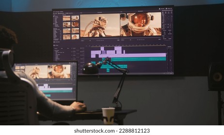 African American colorist makes color grading in video editing software. Multiple monitors with space travel film footage and RGB colour correction graphic bar. Movie post production in modern studio. - Shutterstock ID 2288812123