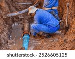 african american construction workers doing some trench digging, metal pipe repairing , water in the trench hole