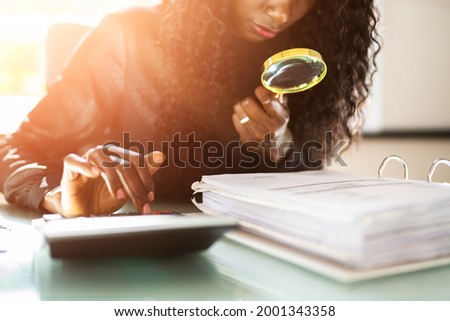 African American Corporate Tax Auditor Using Magnifying Glass