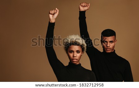 African american couple in black clothes standing supporting black lives matter movement. Couple with raised fists symbolising fight against oppression.