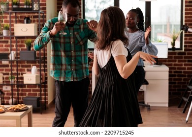 African American Couple Dancing, Enjoying Social Life Accompanied Of Young Adult Caucasian Girl At Diverse Friends Party. Various Nationalities People Drinking Wine, Having Fun.