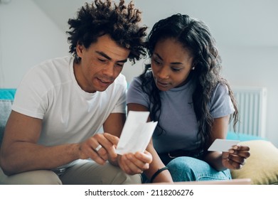 African American Couple Doing Their Accounts At Home And Using A Laptop And A Credit Card For Online Paying. Online Shopping And Purchase. Bills And Family Budget.