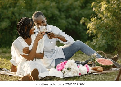 African american couple drinking wine in picnic - Powered by Shutterstock