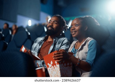 African American couple enjoying in movie projection in cinema.  - Powered by Shutterstock